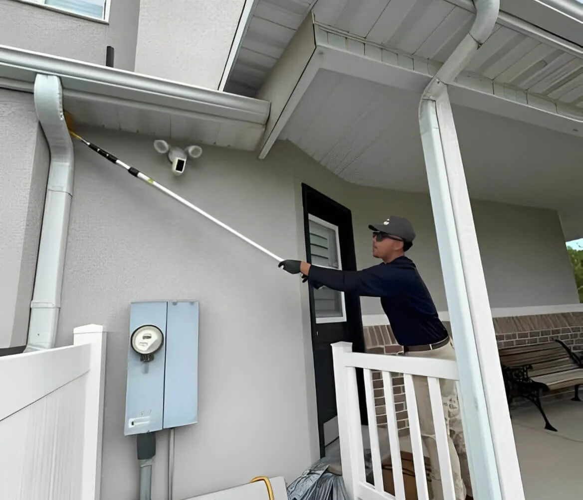 Bliss Pest Services technician treating the eaves of a home's side entry, Salt Lake City pest control