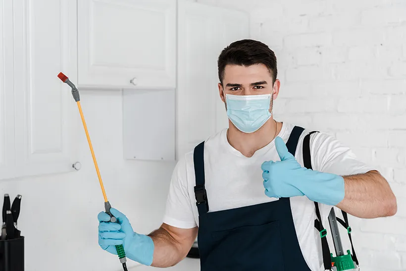 Pest control technician with a sprayer inside a home, residential pest control in Salt Lake City, UT