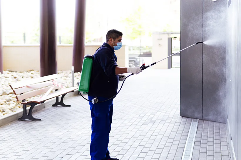 Technician spraying outside a commercial building, commercial pest control in Salt Lake City, UT