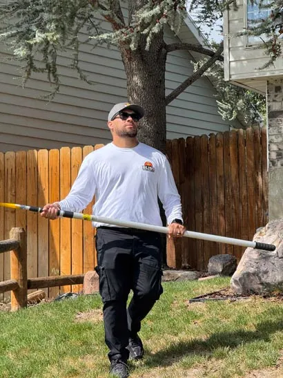 Backyard spray treatment along a wooden fence by a Bliss Pest Services technician, Salt Lake City