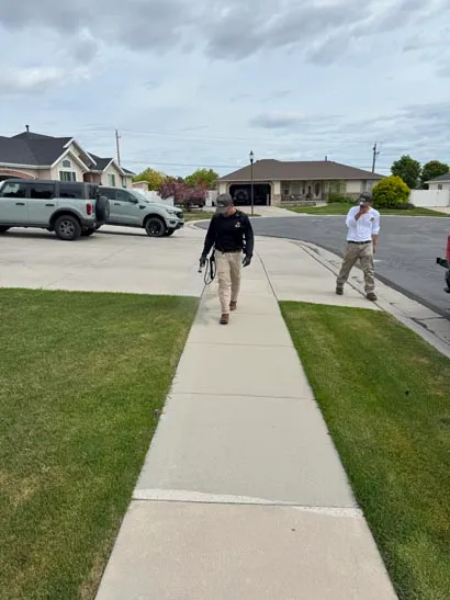 Bliss technician with a sprayer on a residential sidewalk, Salt Lake County exterior pest control